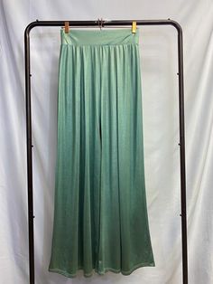 Silky SeafoamGreen Pants Like the smooth waves of the sea washing over the sand. Flow into the room with elegance in these silky mermaid-like pants. These pants are made with a silky, heavy fabric which creates a shimmery drape effect. The legs are flared and create a sleek look. The wide waistband is elastic and the fabric is also stretchy, for a flexible fit. Pleated at the front and the back. Model is 5'2" in 3-inch heels, wearing a size small. Stretch Satin Bottoms For Summer, Stretch Satin Bottoms For Night Out, Elegant Stretch Satin Bottoms, Elegant Satin Stretch Bottoms, Stretch Green Bottoms For Evening, Green Stretch Bottoms For Evening, Satin Bottoms With Elastic Waistband For Night Out, High Waist Green Bottoms For Evening, Summer Evening Stretch Wide Leg Pants