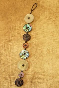 a necklace made out of buttons on a wooden table