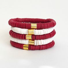 The Game Day Stack is the perfect accent to your game day apparel or to show your school spirit around campus.  These heishi clay disc bracelets in dark red and white are a great graduation gift for the high school or college student in your life.  🎁 All purchases marked as a gift are packaged in a white organza bag so they're ready to gift! Your can even ship straight to the recipient! 📣Who you might be cheering for: Alabama Crimson Tide, Arkansas Razorbacks, Oklahoma Sooners, Stanford  If you yell Roll Tide, Woo Pig Sooie, or Boomer Sooner... this is the stack for you!  ❣️Please note: This is a dark red! (Crimson or Cardinal) Available in sets of 3 or 5 Heishi disc bracelets.  Bracelets are handmade on strong stretch cord and approximately 7 inches in length, which fits small to medium Heishi Bracelets, Woo Pig Sooie, Clay Bracelets, Stacked Bracelets, High School Graduation Gifts, Boomer Sooner, Bracelet Inspo, Disc Bracelet, Great Graduation Gifts