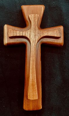 a wooden cross sitting on top of a black surface