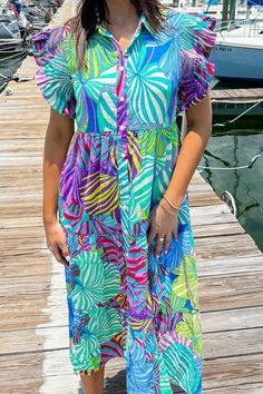 This multicolor printed dress features a collared neckline, smock detailed shoulders, frilled short sleeves, front button-up closure, side pockets, tiered, lined, and midi length. 50% Cotton 50% Rayon Hand Wash Cold. Do Not Wring Or Twist. Non Chlorine Bleach Only. Hang Dry. Low Iron As Needed. May Be Dry Cleaned. Madison is 5’8“ wearing a size Small.Model measurements:Bust: 32 in.Waist: 24 in.Hip: 34 In. Patterned Short Sleeve Summer Maxi Dress, Patterned Short Sleeve Vacation Dresses, Patterned Short Sleeve Maxi Dress For Summer, Colorful Pattern Short Sleeve Summer Dresses, Tiered Multicolor Midi Dress For Vacation, Casual Colorful Ruffled Dresses, Summer Printed Tiered Midi Dress, Summer Multicolor Short Sleeve Midi Dress, Multicolor Short Sleeve Midi Dress For Summer