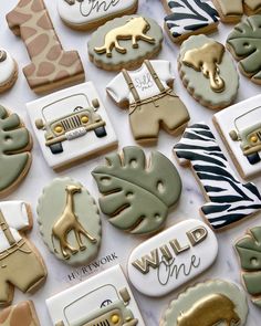 decorated cookies are arranged on a table with zebra, giraffe and jeeps