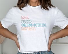 a woman wearing a t - shirt that says eat sleep cross stitch repeat on it