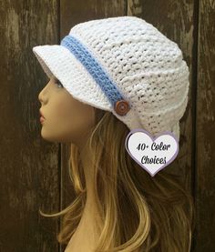 a mannequin head wearing a white crochet hat with blue stripes on the brim