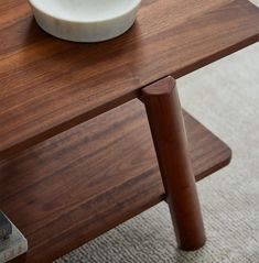 a white bowl sitting on top of a wooden table next to a stack of books