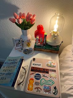 a white table topped with lots of items and a vase filled with tulips