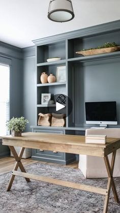 a home office with built - in bookcases and desk