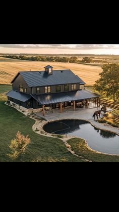 an aerial view of a horse ranch with a pond