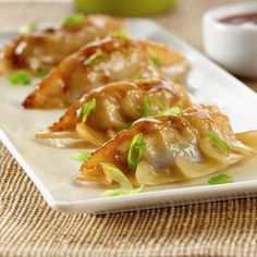 some food is sitting on a white plate and ready to be eaten with dipping sauce