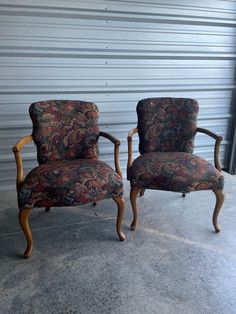 two chairs sitting next to each other in front of a garage door