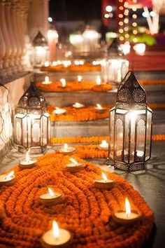 many lit candles are placed on the ground