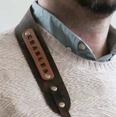 a man wearing a brown leather belt with the word cattle on it's side