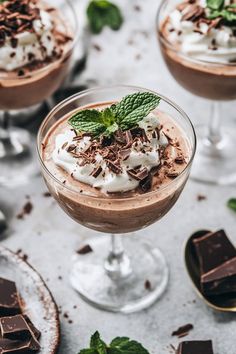 two desserts with chocolate, whipped cream and mint garnish