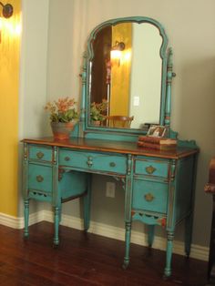 an old dresser has been painted blue with gold trim and is being used as a vanity