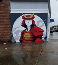 a mural on the side of a building with a woman wearing a red hat and holding an umbrella