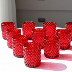 many red glass cups lined up on a table