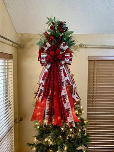 a christmas tree decorated with red, white and green ribbons