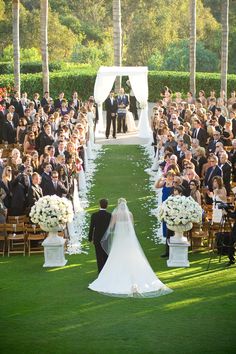 a bride and groom walking down the aisle at their wedding ceremony in front of an audience