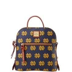 One outside zip pocket. One inside zip pocket. One inside phone pocket. Inside key hook. Zipper closure. Lined. Feet. Handle drop length 3.5". Strap drop length 11.5". Zipper closure. Rectangular Coated Canvas Backpack, Cotton Backpack, University Of Notre Dame, Irish Pride, Notre Dame University, Key Hook, Satchel Tote, Leather Accents, Small Backpack