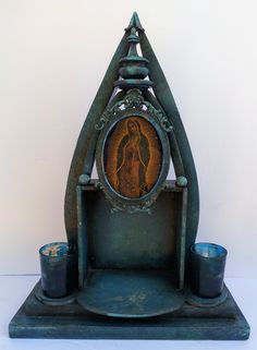 an old clock with the image of jesus on it's face and candles in front