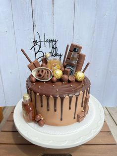 a birthday cake with chocolate icing and candies on the top that says happy birthday