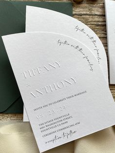 the wedding stationery is laid out on top of each other, with matching envelopes