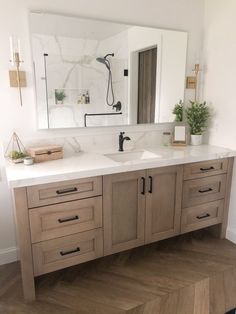 a bathroom with two sinks and a large mirror above the sink is decorated in white marble