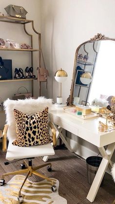 a white desk with a mirror, chair and leopard print pillow in front of it