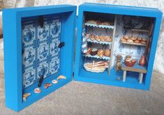 two open blue boxes filled with different types of pastries and other things on display