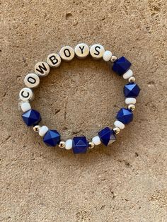 a beaded bracelet with the word cowboys written in white and blue beads on it