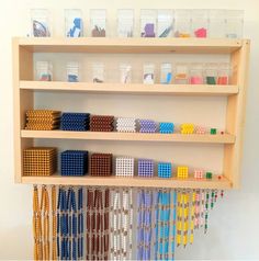 a wooden shelf filled with lots of different colored beads and plastic bins on top of it