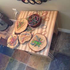 a wooden table topped with lots of crafting supplies on top of a tiled floor