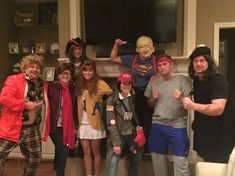 a group of people standing in front of a tv with one person wearing a costume