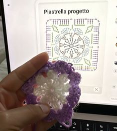 a person holding a crochet flower in front of a computer screen with the words pastarella projetto on it