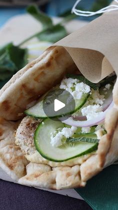 a pita sandwich with cucumbers, onions and feta cheese on it