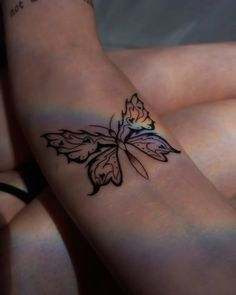 a woman's arm with a butterfly tattoo on the left side of her body