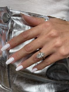 a woman's hand with white manies and a ring on her left hand