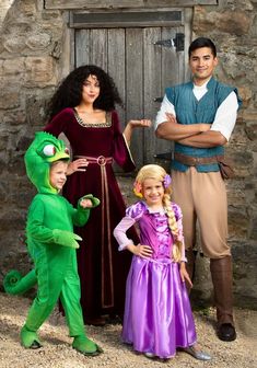 three people in costumes standing next to each other near a stone wall and wooden door