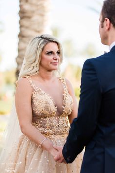 a woman in a wedding dress standing next to a man