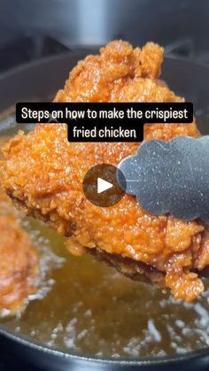 a fried chicken being cooked in a skillet with a spatula on the side