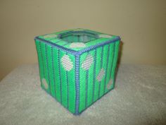 a green and white basket sitting on top of a table