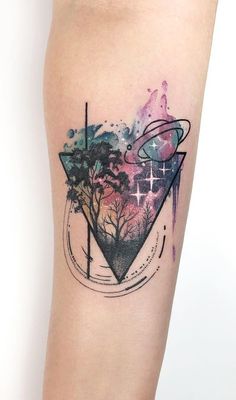 an artistic tattoo on the leg of a woman with trees and mountains in the background