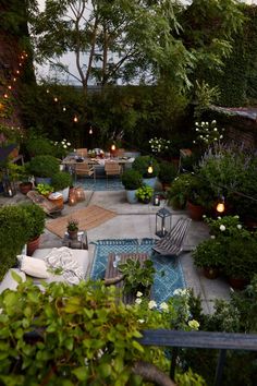 an outdoor dining area is lit up with candles and lights in the middle of it