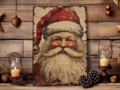 a painting of santa claus on a wood paneled wall with candles and ornaments around it