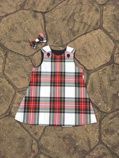 Beautiful handmade in Ayrshire Scotland Tartan Pinafore  Baby girls pinafore dress with button fastening at each shoulder, made in the Stewart Dress Tartan. Fabric is polyester/viscose and the black lining is polyester/ cotton  Comes with pretty matching hair bow. Available in sizes 0-6 months approximate length 14.5 inches 6-12 Months approximate length 16.5 inches 1-2 years approximate length 18 inches 2-3 years approximate length 20.5 inches 3-4years approximate length 21.5 inches I try to ke Tartan Skirts, Ayrshire Scotland, Scotland Tartan, Scottish Dress, Girls Pinafore Dress, Girls Pinafore, Baby Girls Dresses, Tartan Fabric, Tartan Dress