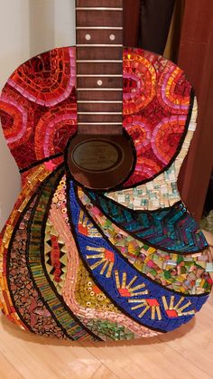 an acoustic guitar made out of colorful fabrics