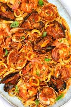 pasta with shrimp, mussels and tomato sauce on a white platter photo