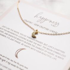 "Our \"Happiness Necklace\" is part of our new \"Self-Love Collection\". The little crescent moon featured in this dainty necklace represents the many phases you go through in life, just as the moon does. It symbolizes comfort as the moon shines so brightly in the darkness of times. Wear it daily to as a reminder that this too shall pass. This makes for a perfect gift for someone (or yourself) going into a new chapter in life. \"Just like the moon, you go through phases. But, life's chapters tea Delicate Moon Phase Charm Necklaces As Gift, Delicate Moon Phase Charm Necklace As Gift, Moon Shaped Charm Necklace With Delicate Chain For Gifting, Moon Shape Charm Necklace With Delicate Chain For Gift, Moon Charm Necklace With Delicate Chain For Gift, Moon-shaped Charm Necklace With Delicate Chain For Gifts, Moon-shaped Charm Necklace With Delicate Chain, Dainty Moon Shaped Charm Necklaces For Gifts, Dainty Moon Charm Necklaces For Gifts