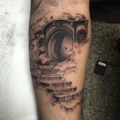 a man with a tattoo on his arm has stairs going up to a hobbot