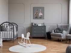 a baby's room with grey walls and furniture